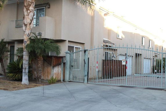 Front view of a multi-story building with a gated entrance.
