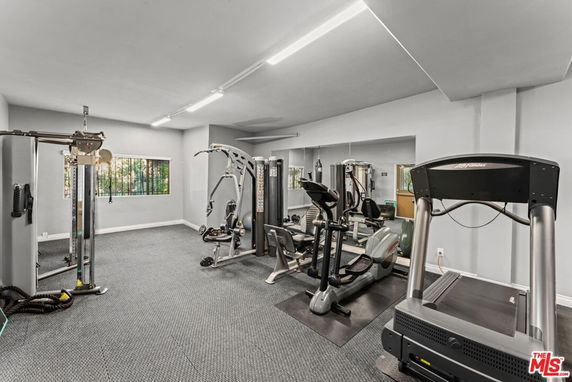 Indoor gym area with exercise equipment including treadmill and weight machines.
