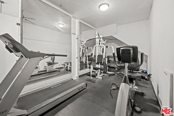 Indoor gym area with exercise equipment and mirrors.