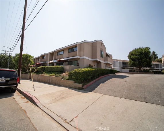 Front view of a modern two-story building with large windows and driveways.