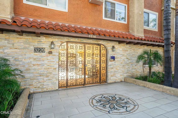 Front view of a building entrance with stone facade and decorative metal gate.