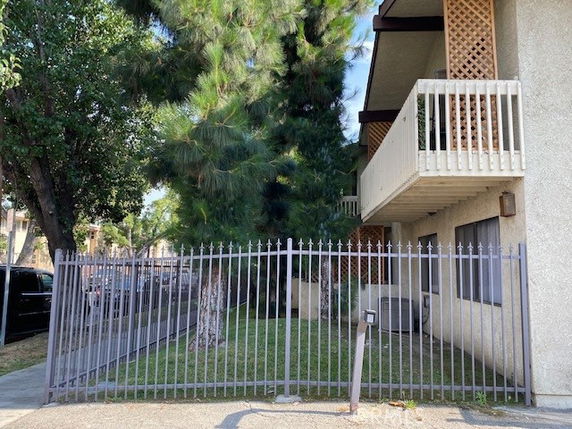 Exterior view of a building with balconies and metal fencing.