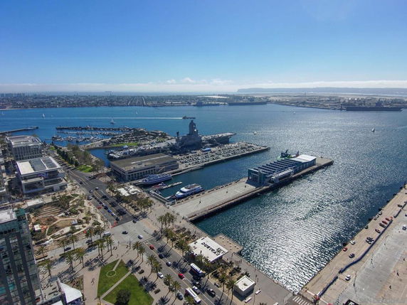Panoramic view of a harbor area with buildings, roads, and waterfront.