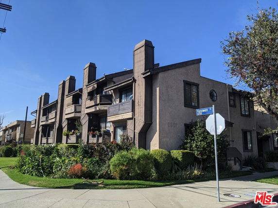 Front view of a multi-story building with balconies and vertical architectural elements.