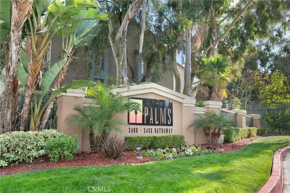 Front view of a building with a decorative entrance sign and landscaping.