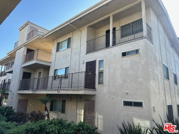 Front view of a multi-story apartment building with balconies.
