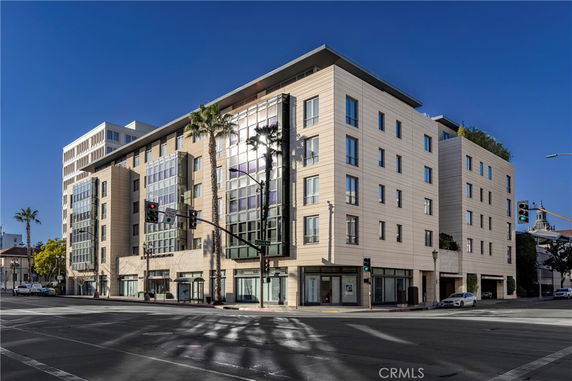Front view of a modern multi-story building on a street corner.