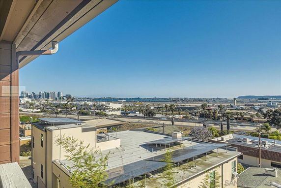 Wide angle view of cityscape from a building, including rooftops with solar panels.