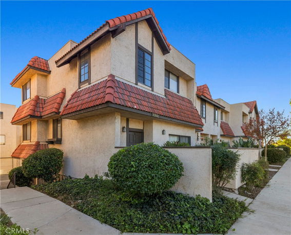 Front view of a multi-story house with red-tiled roof.