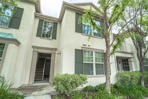 Front view of a two-story townhouse with green shutters and a covered entrance.