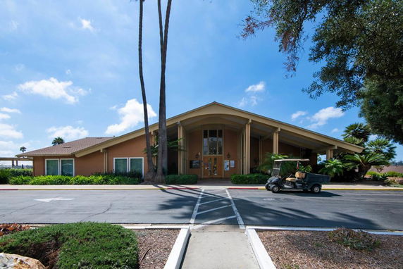 Front view of a single-story building with a large entrance and a sloped roof.