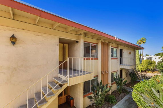 Front view of a two-story apartment building with exterior staircases and balconies.
