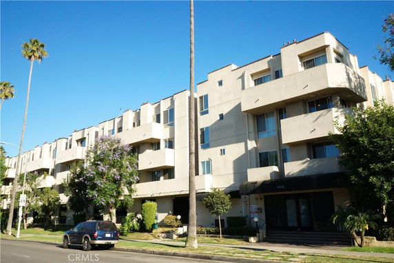 Front view of a multi-story apartment building with balconies.