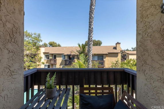 View from a balcony showing neighboring buildings and trees.