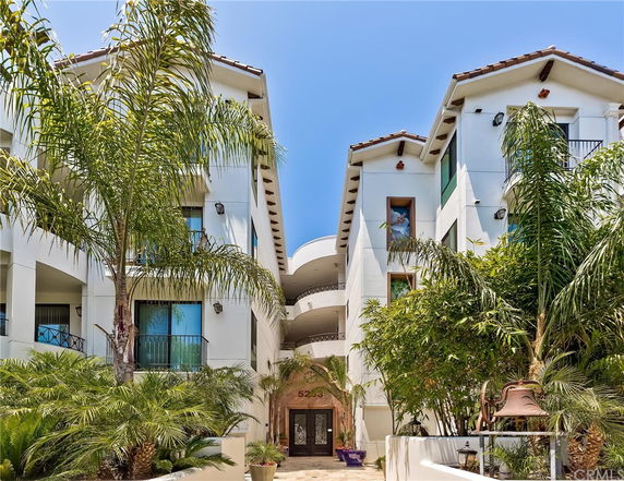 Front view of a multi-story building with white exterior and balconies.