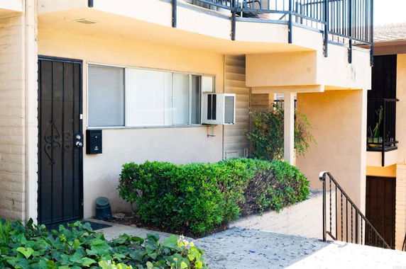 Front view of an apartment entrance with a metal door and window.