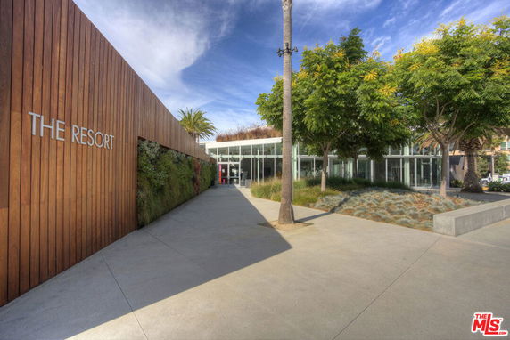 Front view of a modern building labeled 'The Resort' with a wooden facade and glass entry.