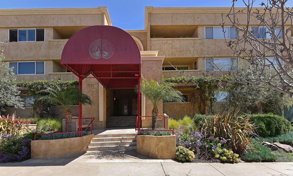 Front view of a multi-story residential building with an entrance canopy.