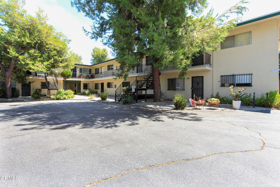 Front view of a two-story apartment building with balconies and outdoor stairs.