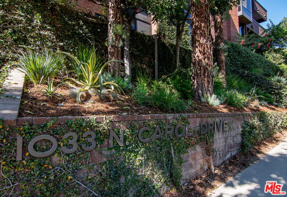 Front view of a building with address number 1033 displayed on a brick wall.
