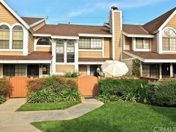 Front view of a two-story townhouse with brown siding and multiple windows.