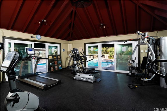 Interior view of a gym with exercise equipment and large windows.