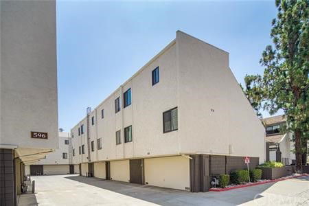 Front view of a multi-story residential building with multiple units and parking area underneath.