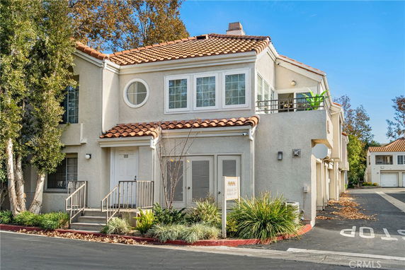 Front view of a two-story house with a tiled roof and balcony.