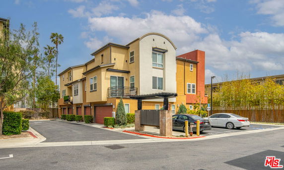 Side view of a multi-story residential building with attached garages.