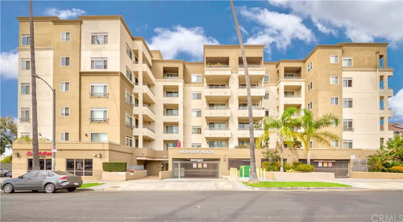Front view of a multi-story building with balconies and a central entrance.