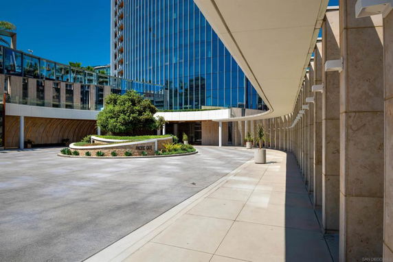 Front view of a modern multi-story building with glass facade and curved entrance area.