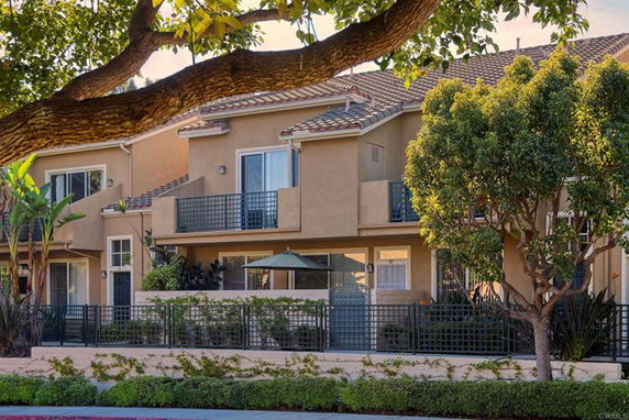 Front view of a two-story residential building with balconies and a tiled roof.