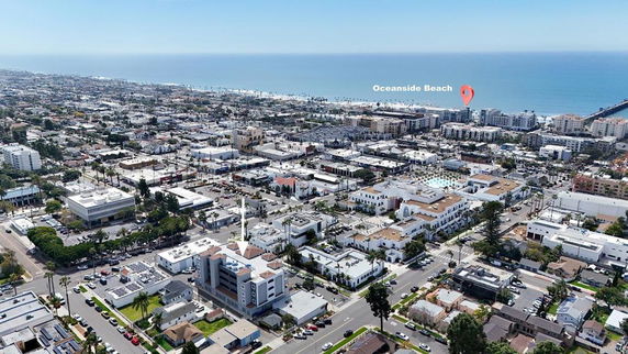 Aerial view of a coastal city with buildings and the ocean in the background.