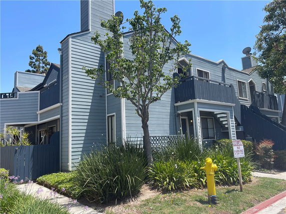 Front view of a two-story building with blue siding and multiple balconies.