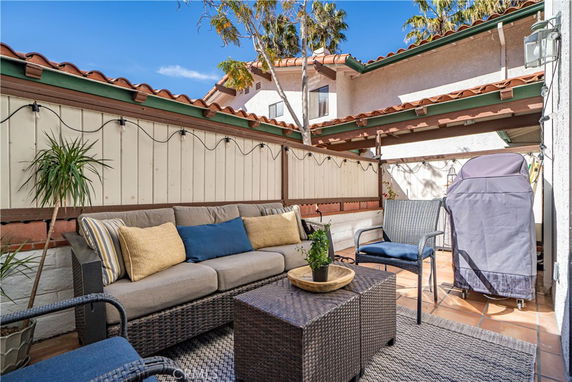Outdoor patio area with seating and a barbecue grill.