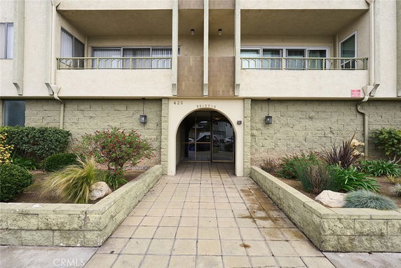 Front view of a building with an arched entrance and balconies.