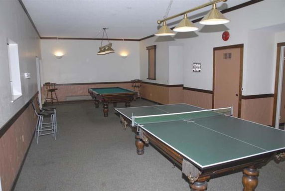 Indoor recreational room with a ping pong table and a billiards table.