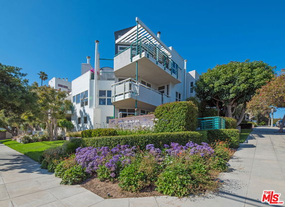 Front view of a modern multi-story building with balconies.