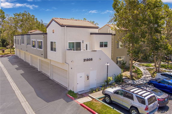 Front view of a multi-family residential building with garages on the ground floor.