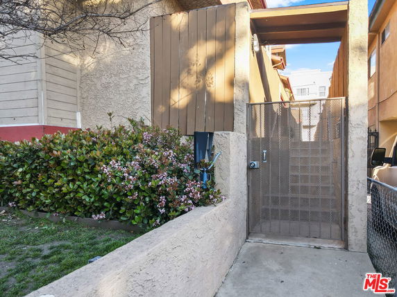 Front view of a gated entrance with stairs leading up to a structure.