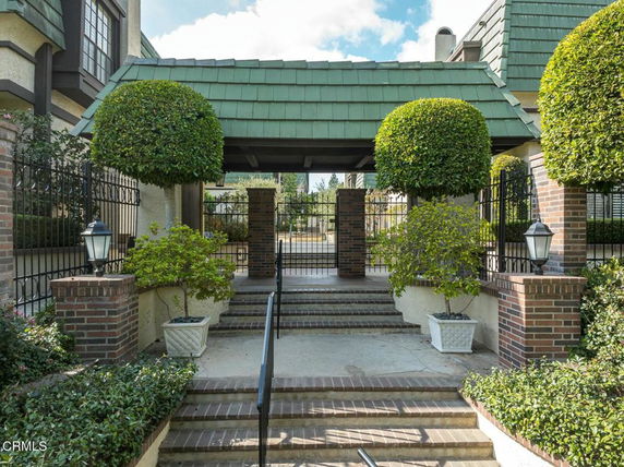 Front view of a building with green-roofed entrance and brick columns.
