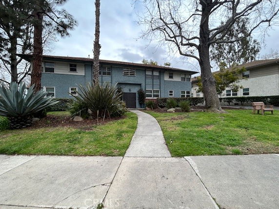 Front view of a two-story building with a pathway leading to the entrance.