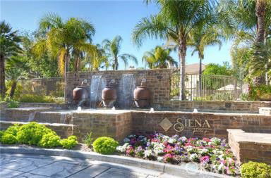 Brick wall with three water fountains and a sign that says 'Siena'.