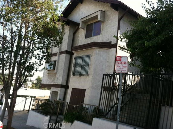 Front view of a multi-story residential building with metal window bars.