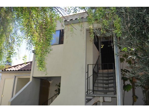 Front view of a two-story building with external staircase.