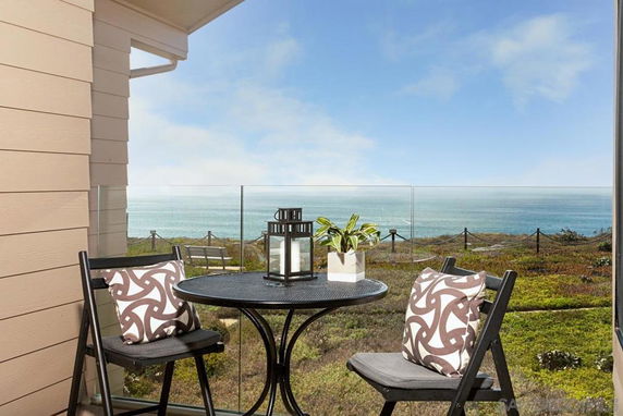 Outdoor seating area with ocean view from a building.