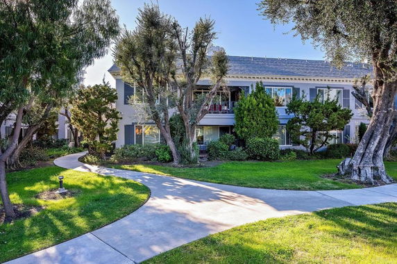 Front view of a two-story residential building with a garden walkway.