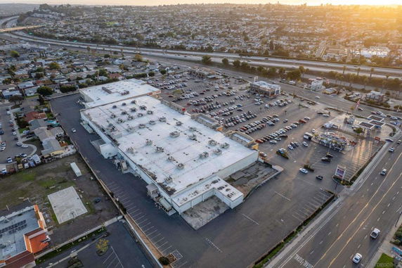 Aerial view of a large building complex with surrounding roads and parking areas.