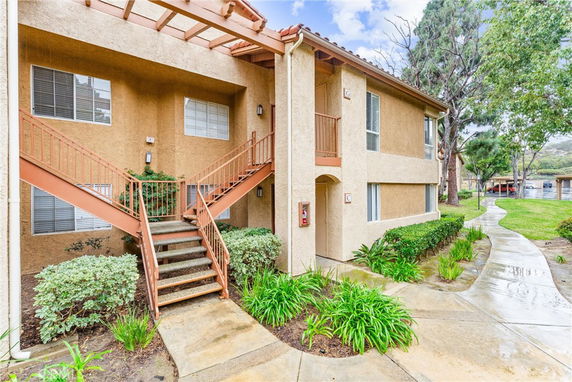 Front view of a two-story apartment building with external stairs.