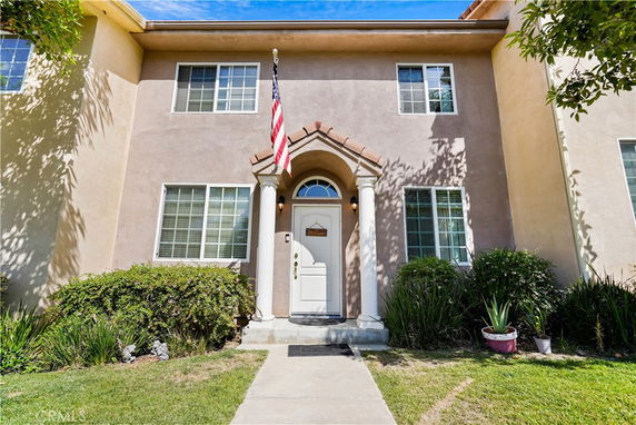 Front view of a two-story house with a central entrance and multiple windows.